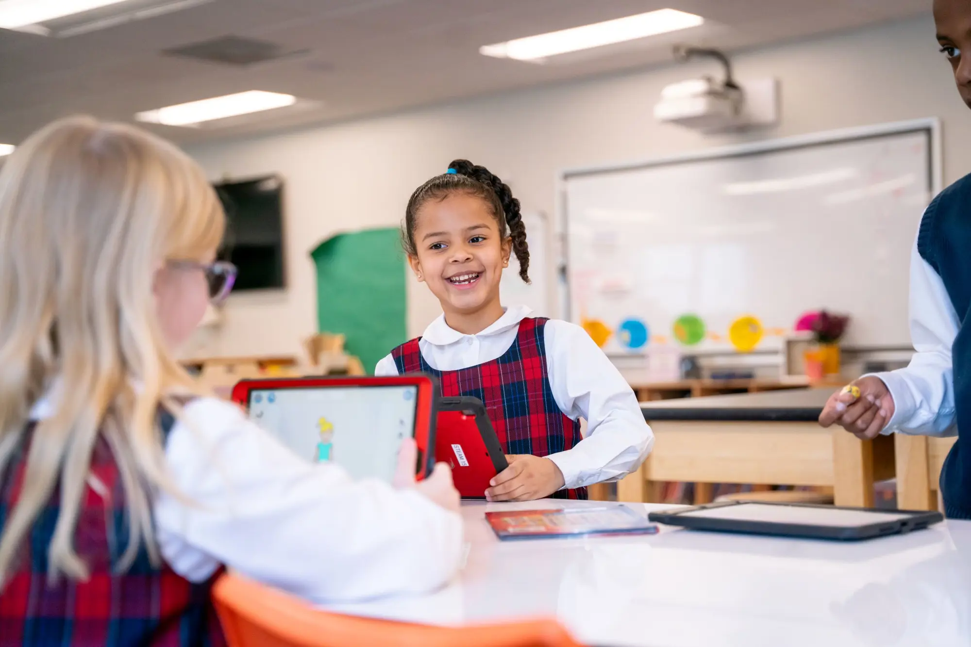 Lower School student smiles at a table in a STEAM classroom